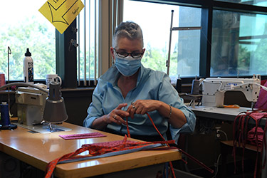 An MJC student makes protective masks in the costume shop.
