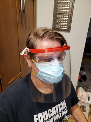 A 3d printed headband holds a clear plastic shield to protect the face of healtcare workers